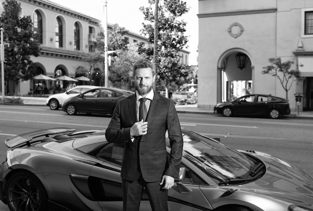 Photo confident business man rent car ceo stand by luxury automobile successful dealer