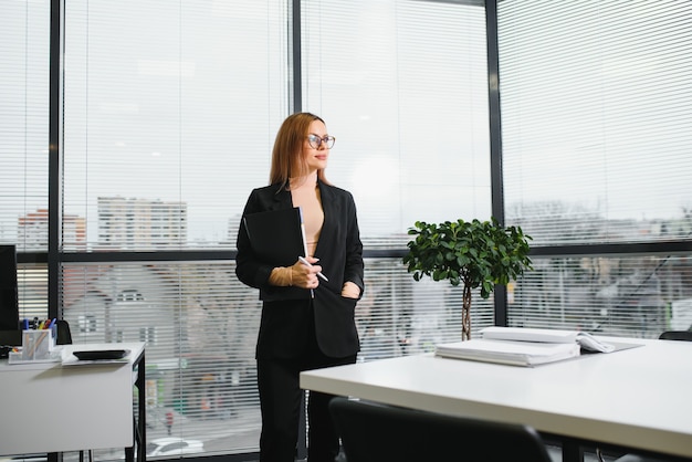 Confident business woman stands in the office