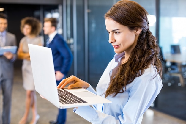 Confident business woman using laptop in office with her teamblack