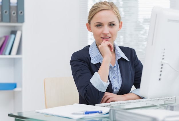 Confident business woman with computer at office desk