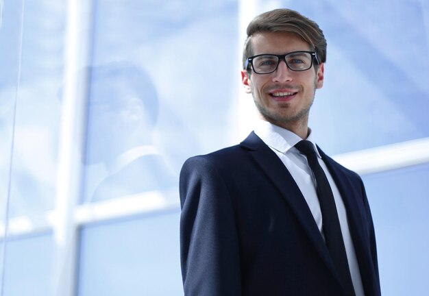 Confident businessman on background of office windowphoto with copy space