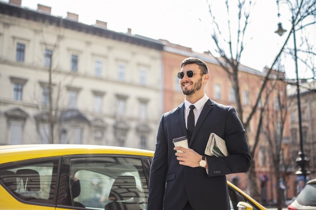 Confident businessman next to a cab