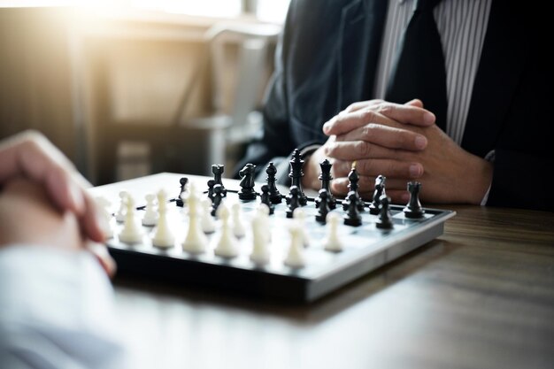 Confident businessman colleagues playing chess game overcome the fear of confrontation to development analysis new strategy plan leader and teamwork concept for success