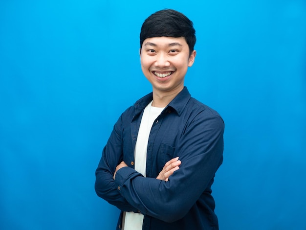 Confident businessman cross arm with happiness smile cross arm blue background