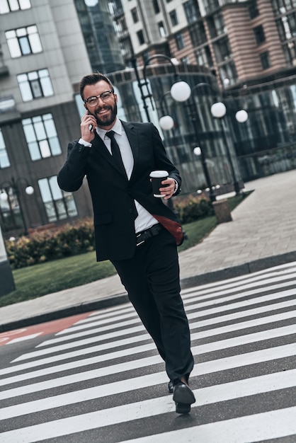 confident businessman. full length of young man in full suit talking on the phone and smiling 