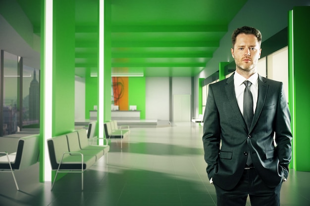 Confident businessman in green lobby