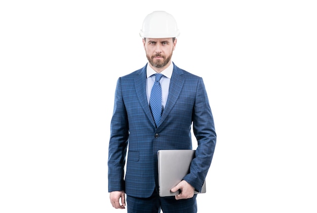 Уверенный бизнесмен в костюме и защитном шлеме держит ноутбук изолированным от белого бизнеса