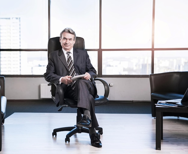 Photo confident businessman in the office sitting in a chair