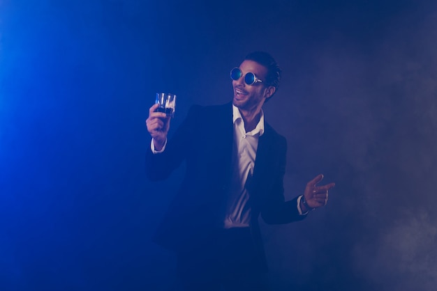 Confident businessman posing in the dark room