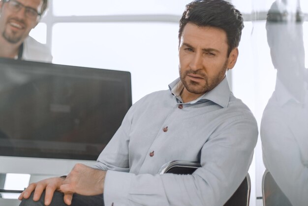 Photo confident businessman sitting at a computer table