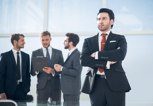 Confident businessman standing in the background of the officebusiness people