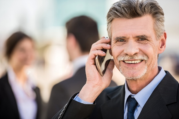 Foto uomo d'affari sicuro in vestito che parla sul telefono.