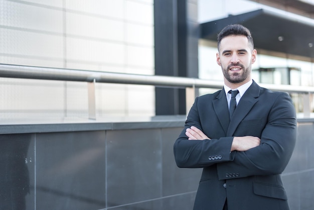 Confident businessman wearing suit and standing at office area in city looking away