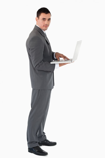 Confident businessman with laptop against a white background