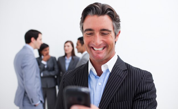 Confident businessman writing a text with a mobile phone