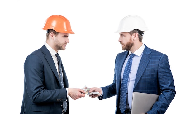 Confident businesspeople men in suit and safety helmet giving money and hold computer bribe