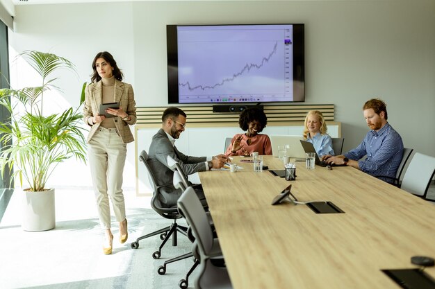 A confident woman standing at the head of a boardroom table