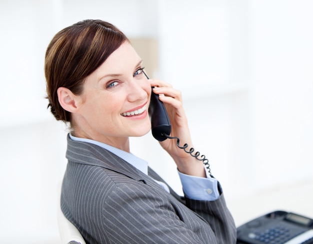 Confident businesswoman on phone sitting at her desk 