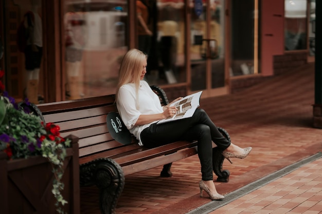 A confident businesswoman sitting on the bench working over the project