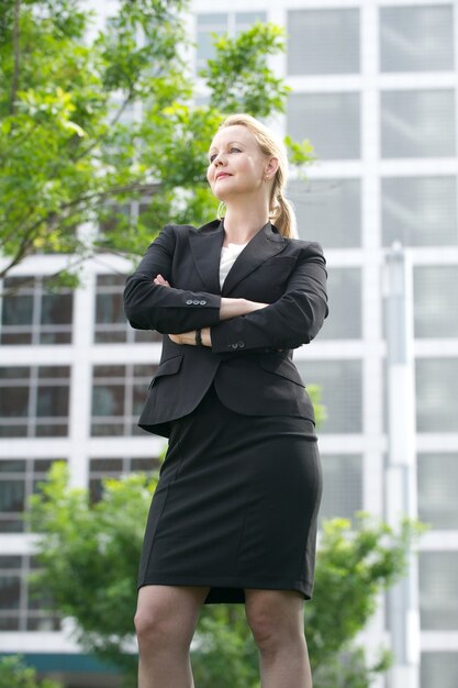 Confident businesswoman standing outside the office