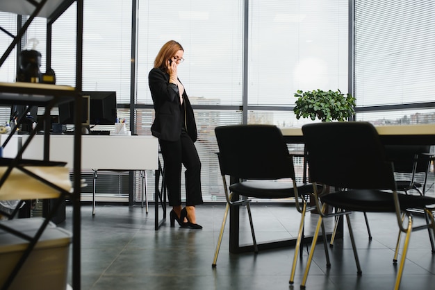 Фото Уверенная деловая женщина стоит в офисе