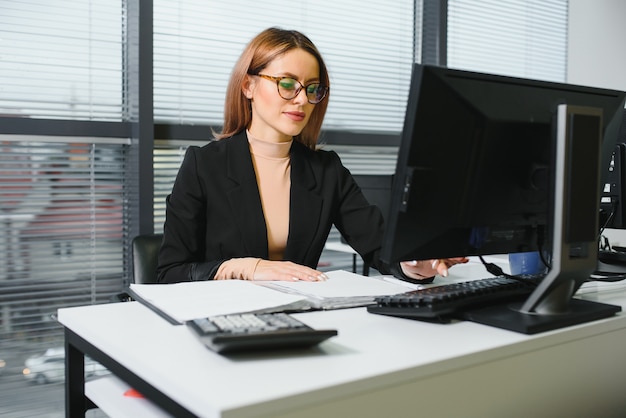 Confident businesswoman stands in the office