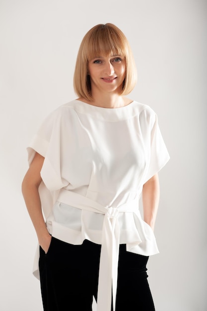 Confident businesswoman in white formal suit on background