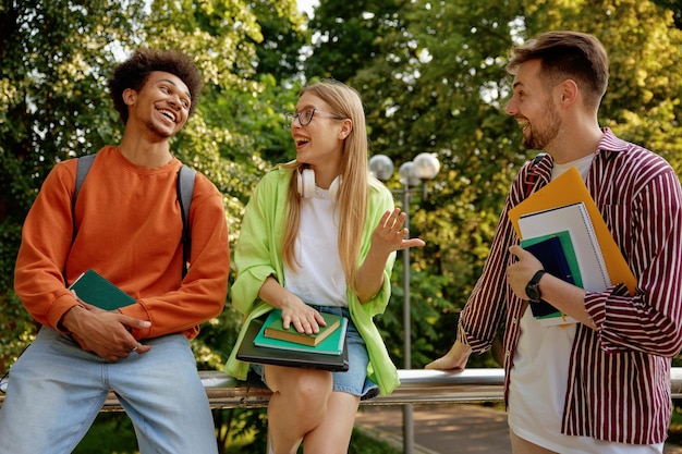 Confident casual teenage students laughing and sharing good mood. Friends spending time outdoor after college classes