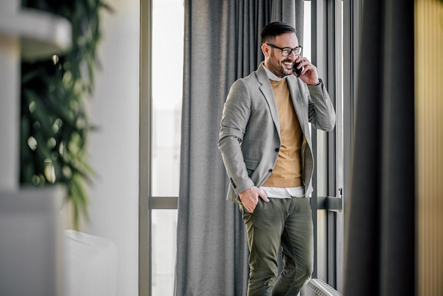 Confident caucasian man laughing out loud talking on the phone