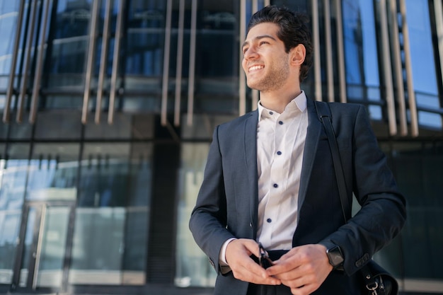 A confident CEO male manager walking into the office in a formal suit smiles thinks