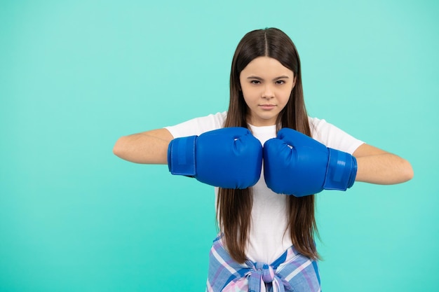 Фото Уверенный ребенок-боксер в боксёрских перчатках во время спортивной тренировки