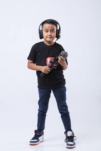 Confident and creative Asian child blogger talking on camera in a studio. Online influencer vlogger.