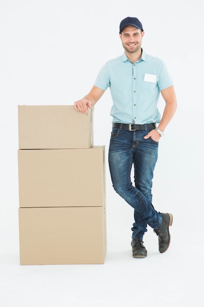 Confident delivery man with cardboard boxes