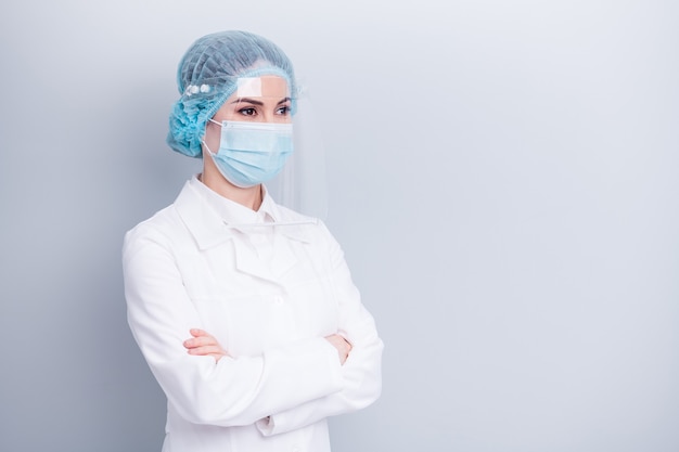 confident doctor lady wear protective medical mask shield isolated on grey wall