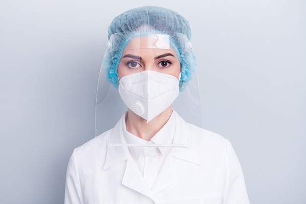 confident doctor lady wear protective medical mask shield isolated on grey wall