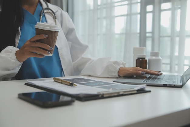 Confident doctor man holding a pill bottle and writing while talking with senior patient and reviewing his medication at office room