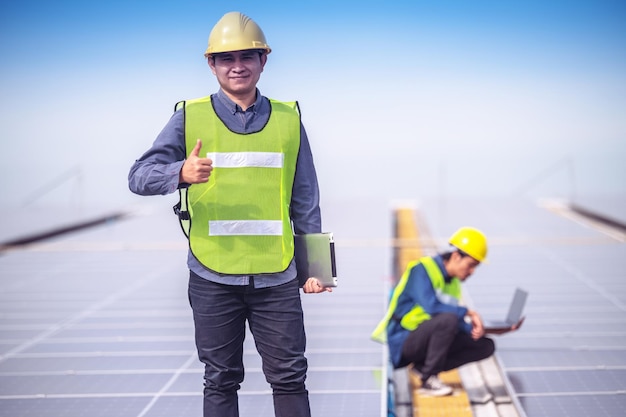 Confident Engineer standing check on Solar power energy at rooftop factory