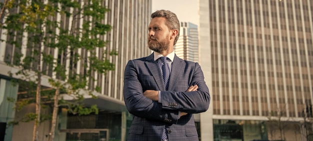 ビジネスライクなスーツを着た自信のある起業家がオフィスのカリスマ性の外で手を組んだ
