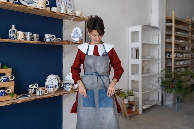 Уверенная в себе предпринимательница мастерит женщину в гончарной мастерской, готовящуюся к мастер-классу или рабочему процессу