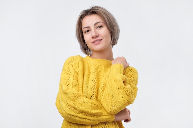 Confident european woman smiling against gray background