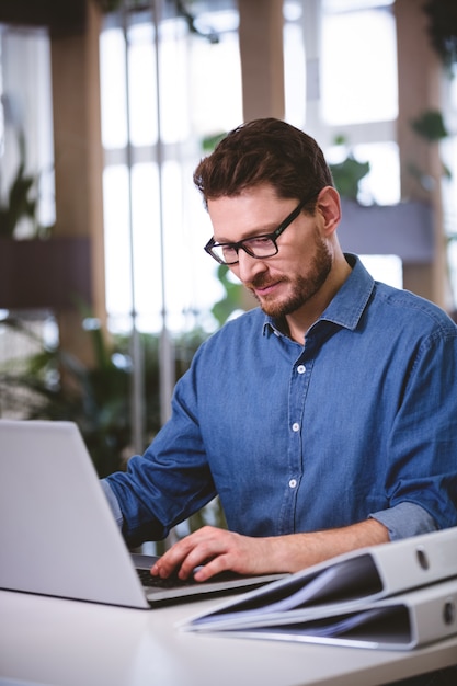 confident executive working on laptop at creative office