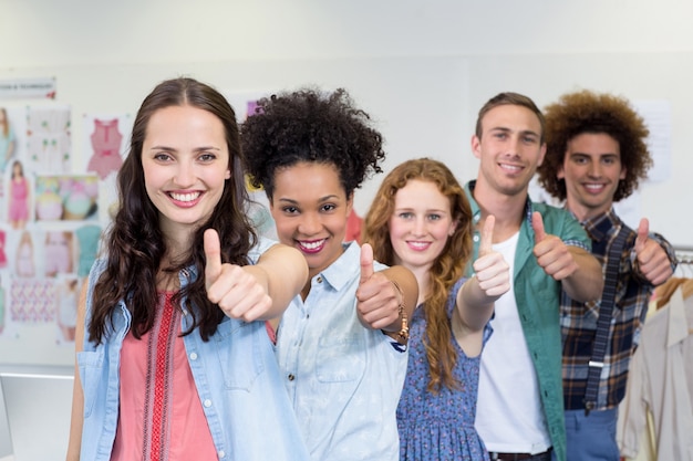 Confident fashion designers gesturing thumbs up