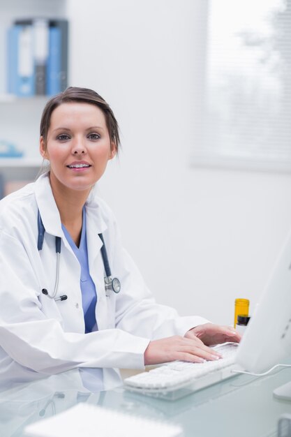 Confident female doctor using computer at clinic