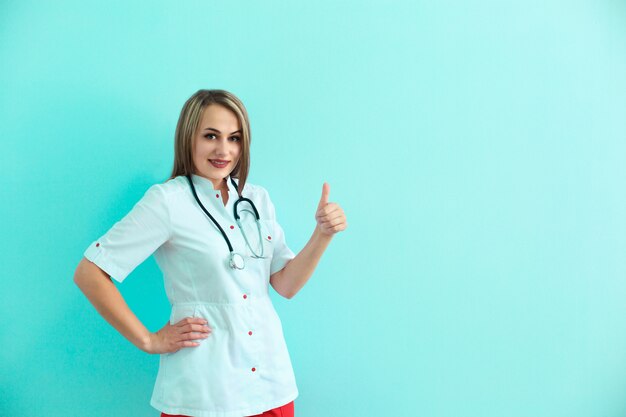 Confident female doctor with stethoscope and backpack shows thumb up 