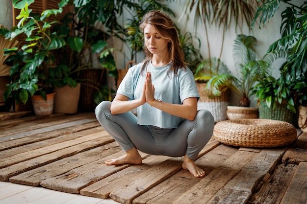 A confident female instructor is engaged in yoga in the asana pose Harmony in the soul and body Sports fortitude exercises for health Aerobics trainer warming up joints and muscles