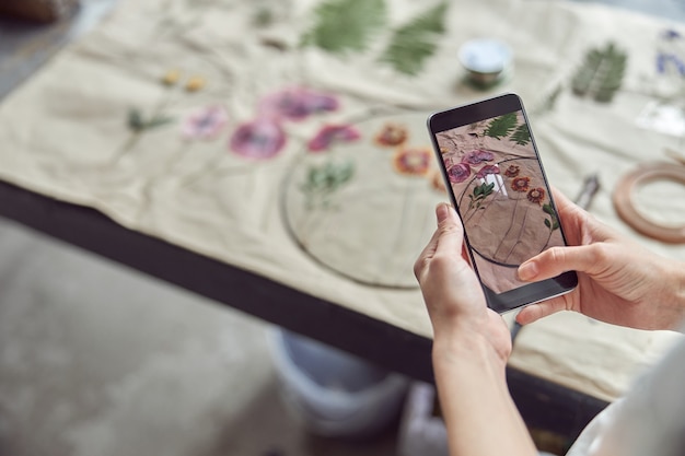 Confident female woman is taking photo on her smartphone