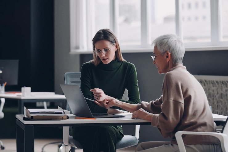 Photo confident financial advisor discussing options with senior woman in the office