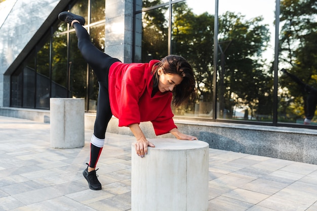 Confident fit sportswoman doing exercises outdoors