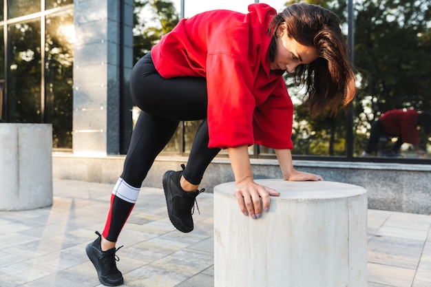 Confident fit sportswoman doing exercises outdoors