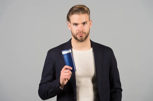 Confident in hair care product Man stylish hairstyle holds bottle hygienic product grey background Switch matte products if thinning Men hair thins out Matte products make hair appear thicker